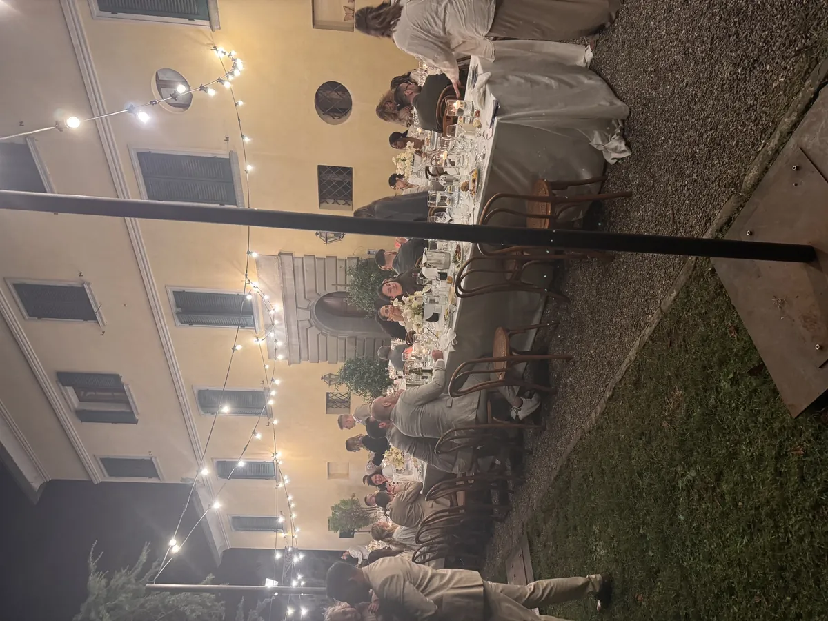 Festlich gedeckte Abendtafel unter Lichterketten im Garten einer Villa