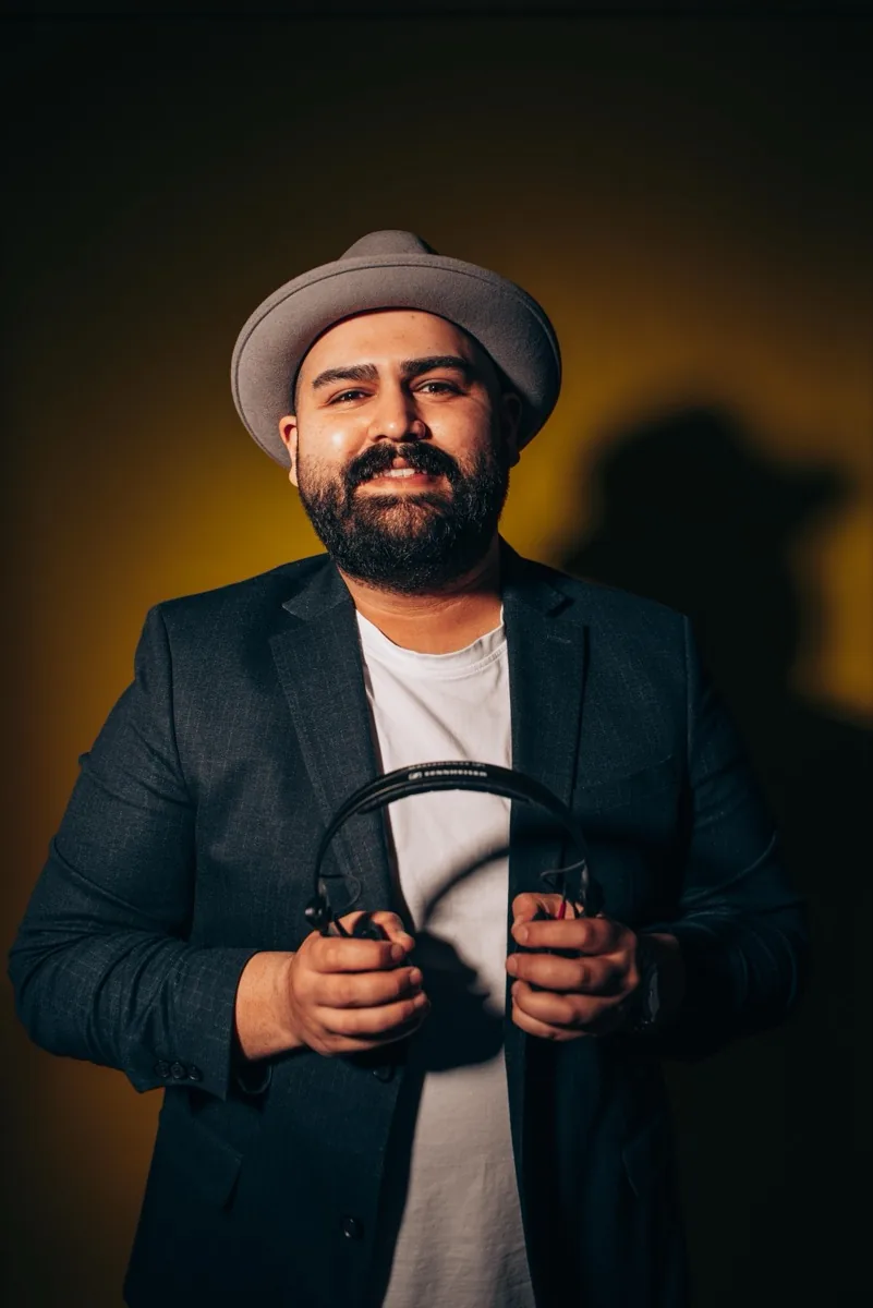 DJ SAM l&auml;chelt am DJ-Pult w&auml;hrend einer Feier