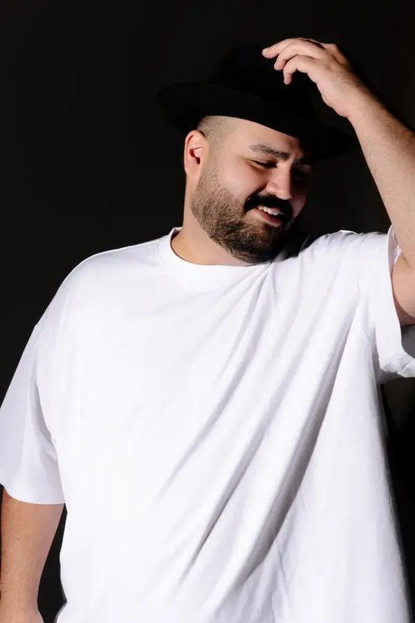 DJ SAM mit wei&szlig;em Shirt und Hut &ndash; l&auml;ssig l&auml;chelnd