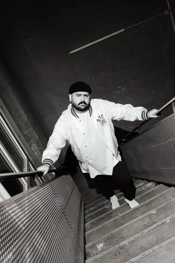 DJ SAM im wei&szlig;en Jacket auf Treppe &ndash; Schwarzwei&szlig;
