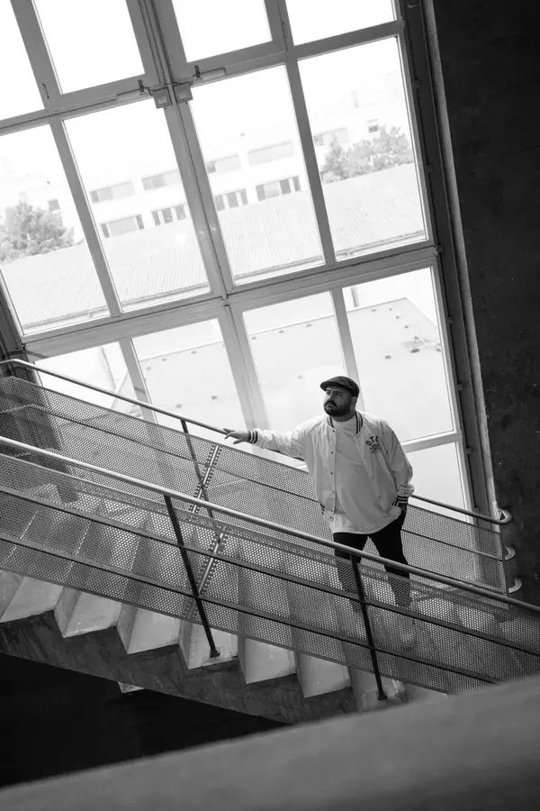 DJ SAM auf Treppe mit gro&szlig;em Fenster &ndash; Schwarzwei&szlig;