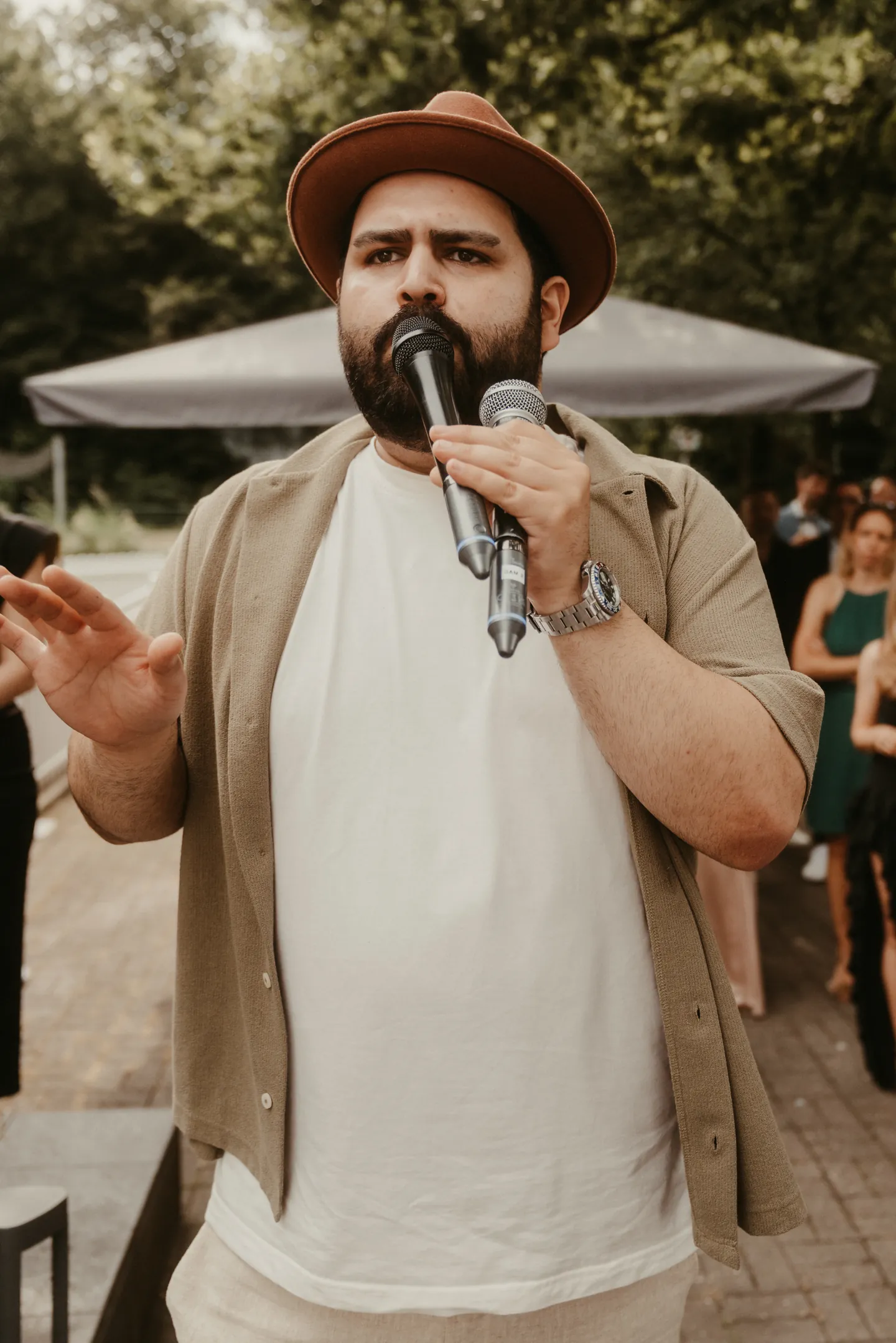 DJ SAM mit Mikrofon bei der Moderation im Freien unter B&auml;umen an der Festscheune am &Uuml;mminger See