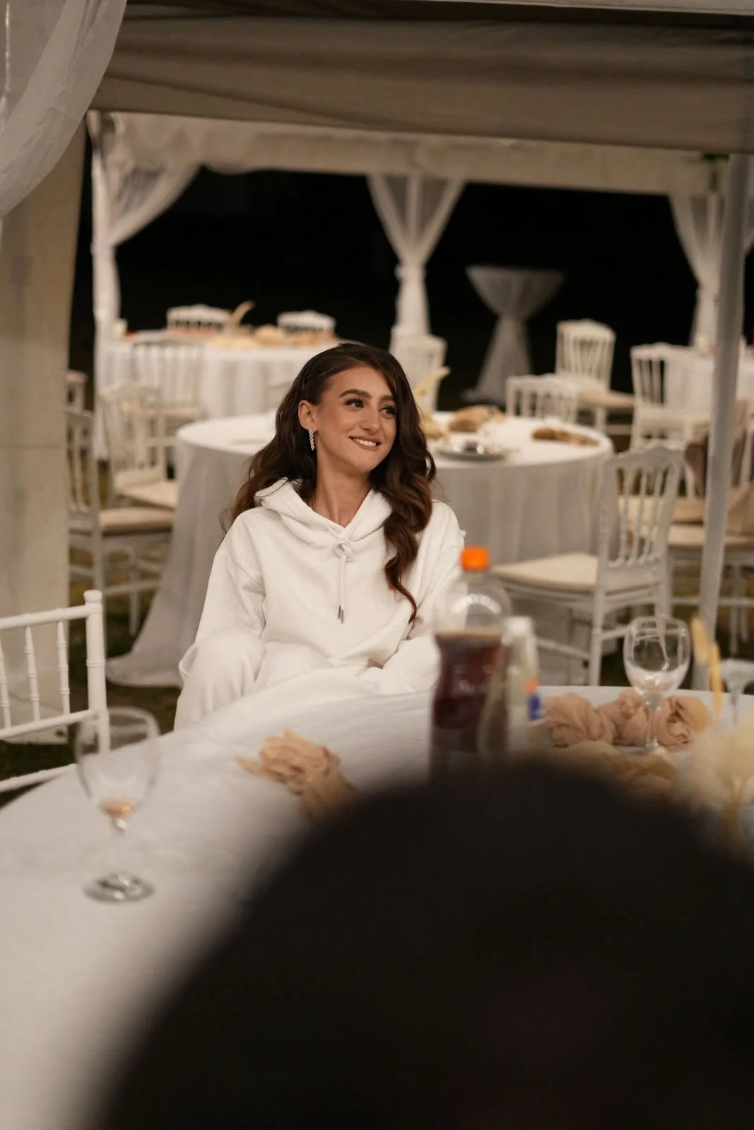 Die Braut entspannt im wei&szlig;en Wedding-Jogger am Tisch der Hochzeitsfeier