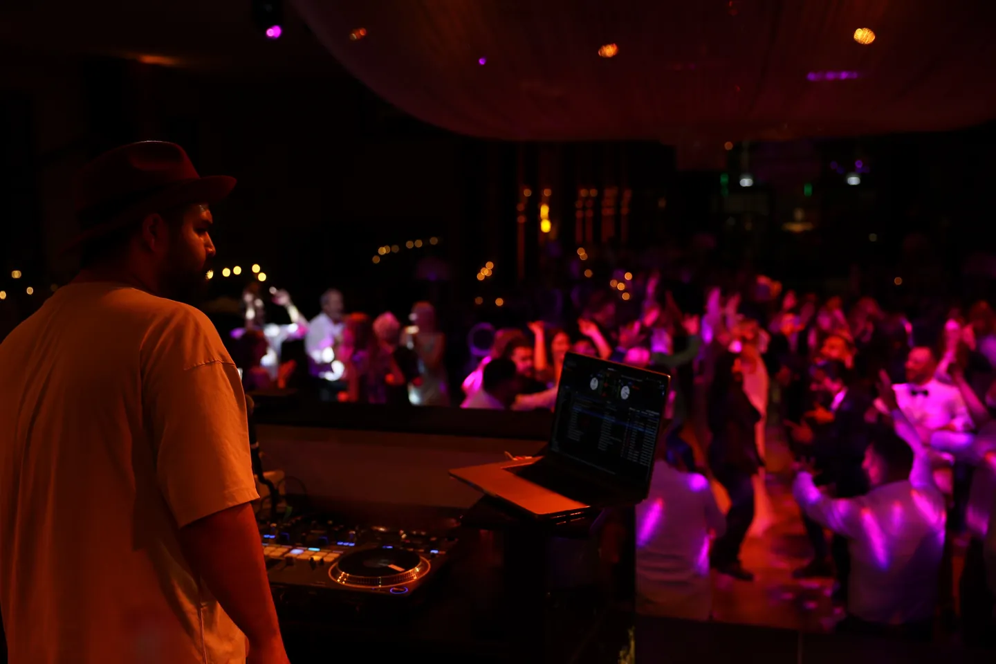 DJ SAM am Pult vor voller Tanzfl&auml;che in pinkem Licht im Lavie bei K&ouml;ln