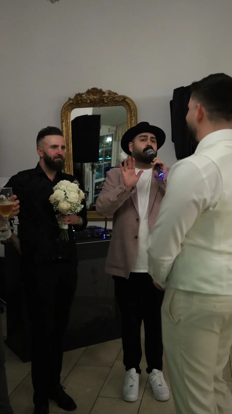 DJ SAM moderiert im festlichen Saal der Winterhochzeit in Weiden, neben ihm G&auml;ste mit dem Brautstrau&szlig;