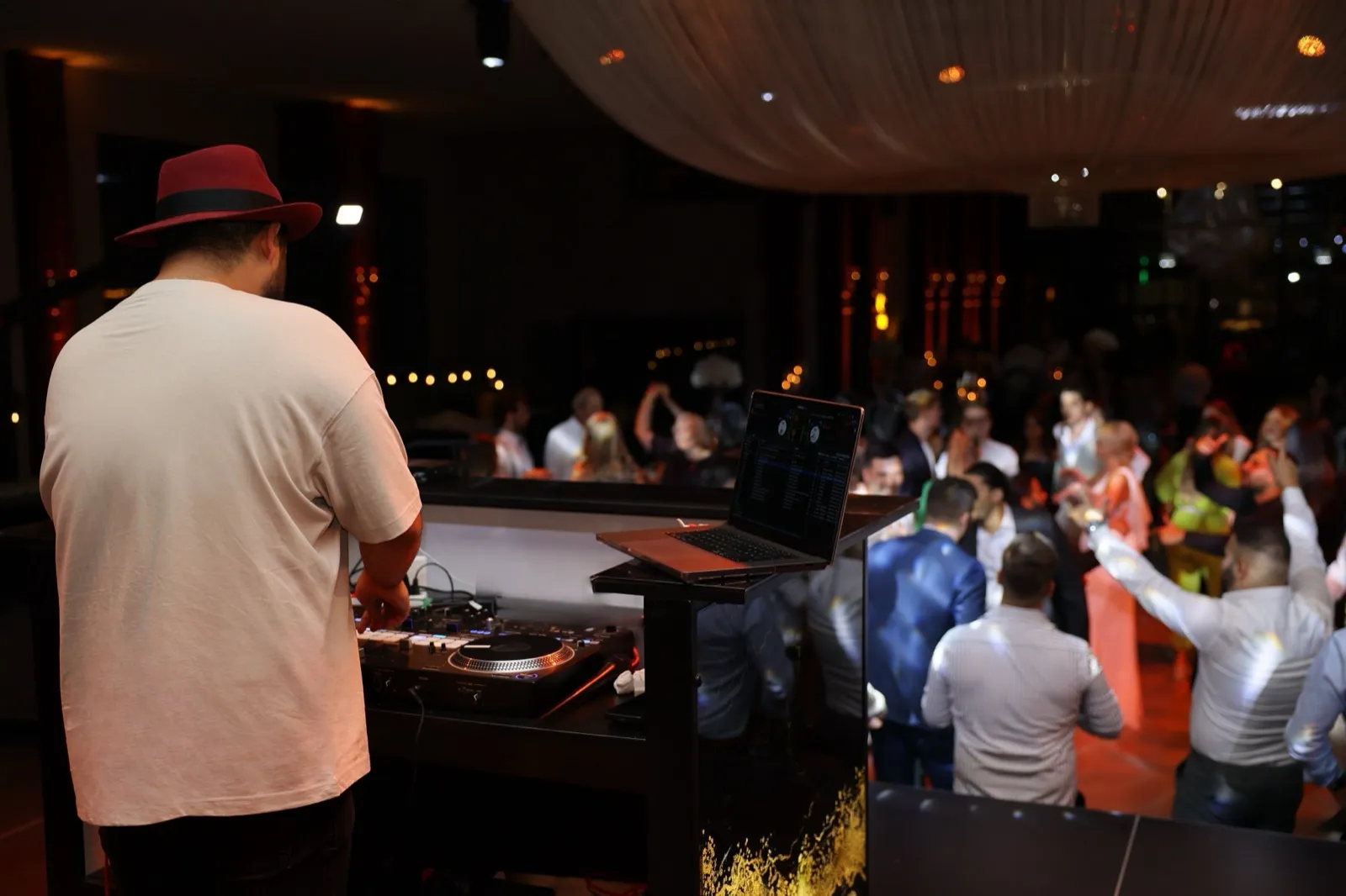 DJ SAM am Pult mit Blick auf die volle Tanzfl&auml;che